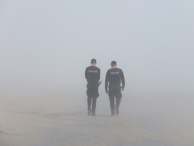 Dvaja policajti v uniformách kráčajú po zasneženej krajine